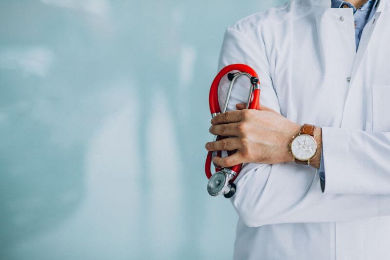 Médico segurando estetoscópio no corredor do hospital